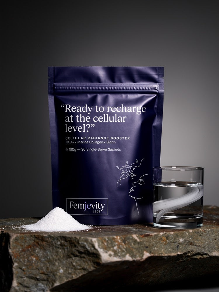 The Femjevity Labs Cellular Radiance Booster pouch open beside a spill of fine white powder and a glass of water, on a stone surface.